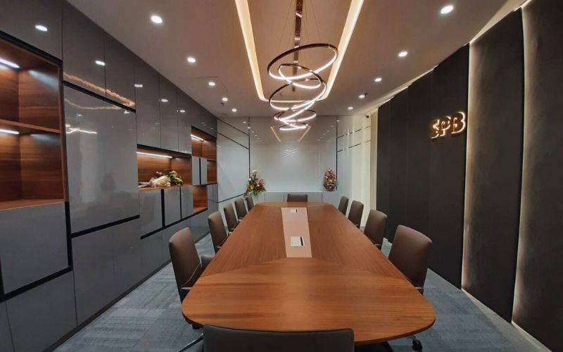 A modern conference room featuring a long table surrounded by chairs, designed by office interior designers in Bangalore.