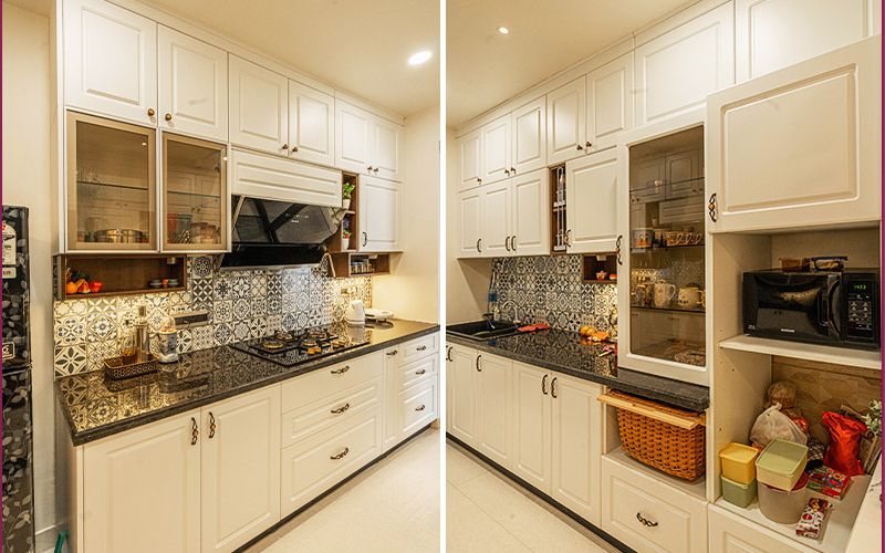 A modern kitchen featuring white cabinets and sleek black countertops, designed by home interior designers in Bangalore.