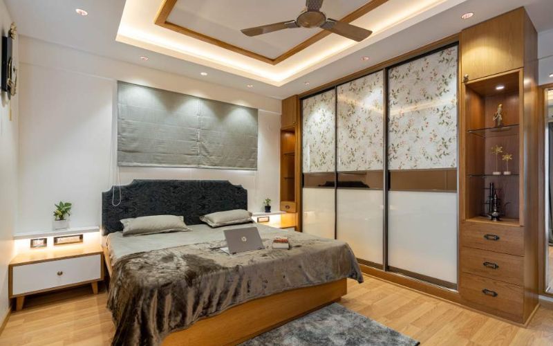 Bedroom with bed, dresser, and ceiling fan. Interior designing company in Bangalore.