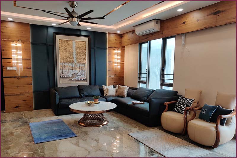 A well-designed living room with a couch, coffee table, and ceiling fan, exemplifying interior design trends in Bangalore.