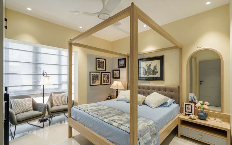 A stylish bedroom featuring a canopy bed and a decorative mirror, showcasing modern interior design elements.