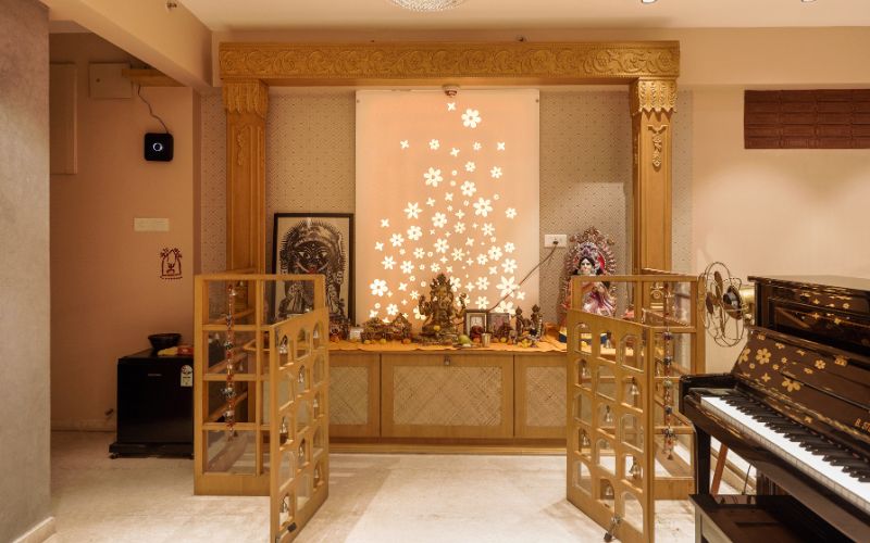 A beautifully designed puja room with a piano and a striking gold door, creating a peaceful space for reflection and music.