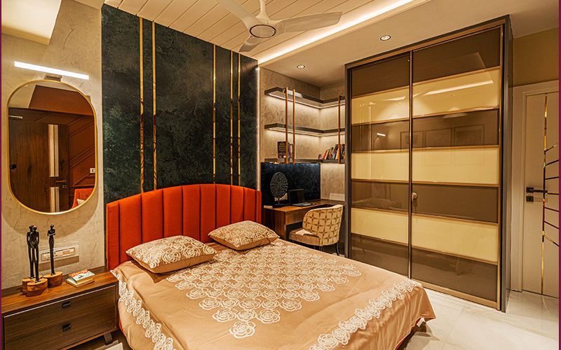 A stylish bedroom featuring a bed, desk and mirror, showcasing modern interior design in Kolkata.