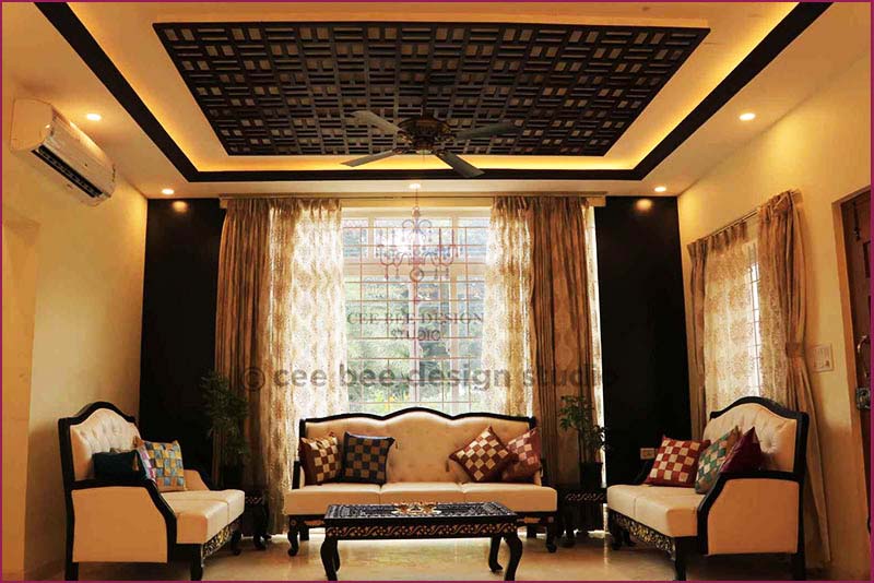 Interior design of a bedroom in Kolkata with bed, desk, and fan.