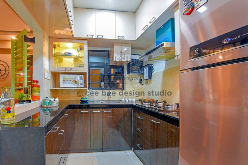 Kitchen with refrigerator, sink, and counter top in 3bhk apartment.