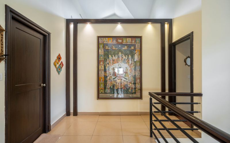 A hallway featuring a decorative painting on the wall, complemented by a classic wooden door, showcasing elegant home design.