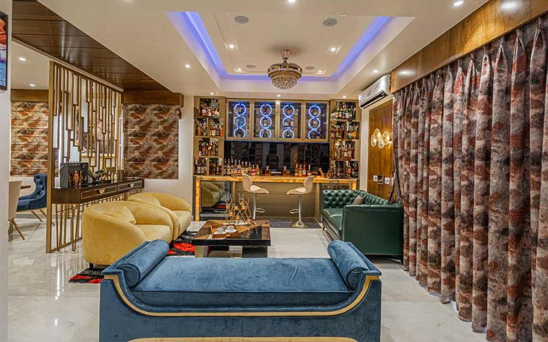 A stylish living room featuring elegant blue and gold furniture, designed by an interior designer in Kolkata.