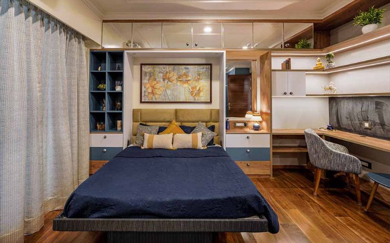 Elegant bedroom interior showcasing a bed, desk, and cabinets, crafted by a Kolkata-based designer.