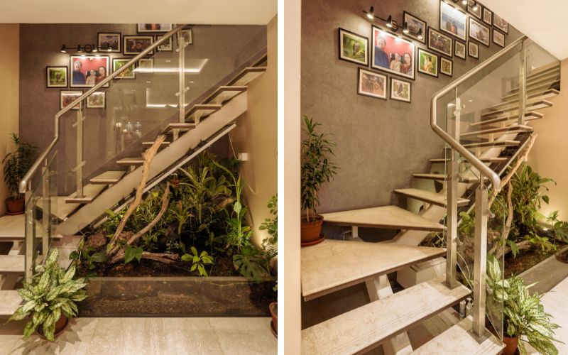 A beautifully designed staircase adorned with plants and framed pictures, showcasing the work of top interior designers in Kolkata.