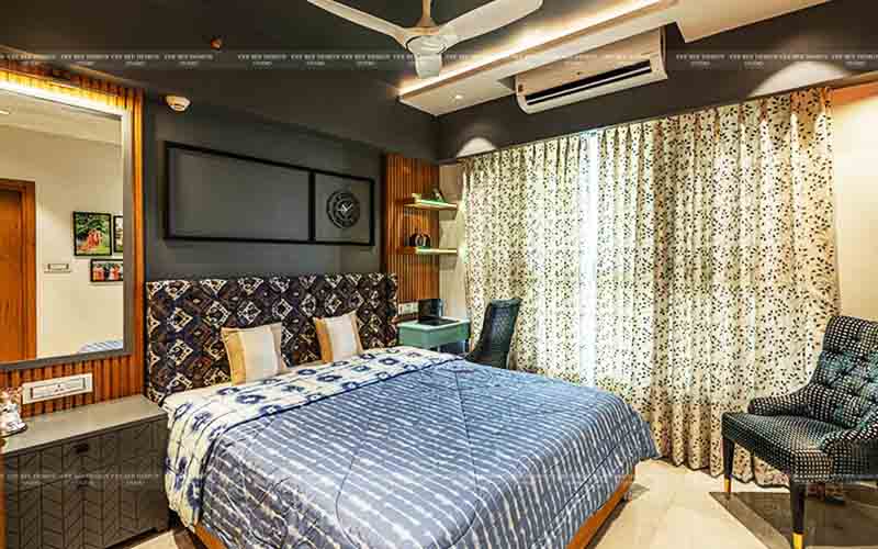 A bedroom with a green wall and wooden floor, showcasing home interior design in Kolkata.