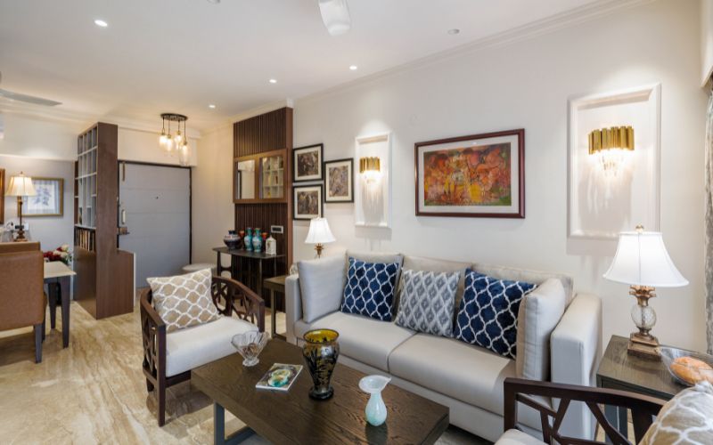 A stylish living room featuring comfortable couches, elegant chairs, and a modern coffee table, designed by Kolkata interior firms.