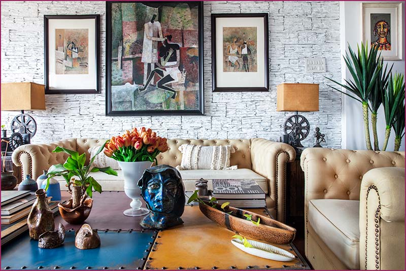 English style living room with a cozy couch, coffee table, and vibrant paintings, designed by a Kolkata interior designer.