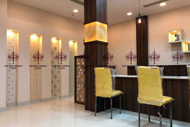 Interior designer in Kolkata created a reception area with yellow chairs and a counter.