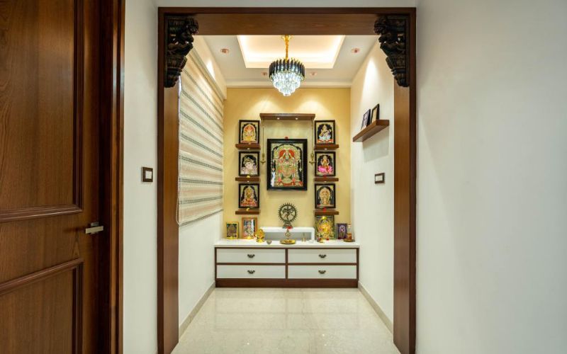 A hallway with a wooden door and a small shrine, showcasing puja room interior design.