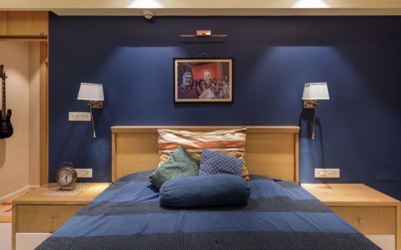 Modern bedroom adorned with blue walls and a comfortable bed, reflecting the design skills of a Kolkata interior designer.