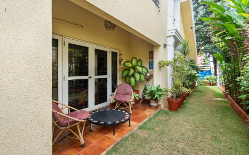 A cozy patio featuring chairs and lush plants, enhancing the charm of a house designed by top interior designers in Kolkata.