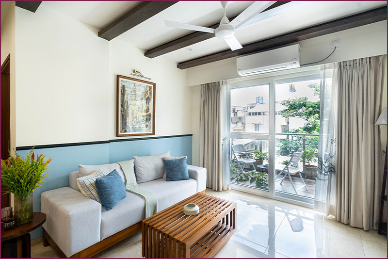 A cozy living room with a couch, coffee table, and a window, showcasing elegant home interior design.