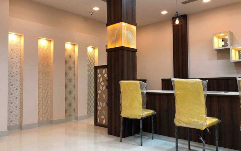 Interior design in Kolkata of a jewellery store showcasing a reception area with vibrant yellow chairs and an elegant counter.