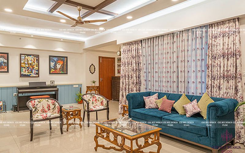 Living room with blue couches and a ceiling fan, designed by a turnkey interior designer