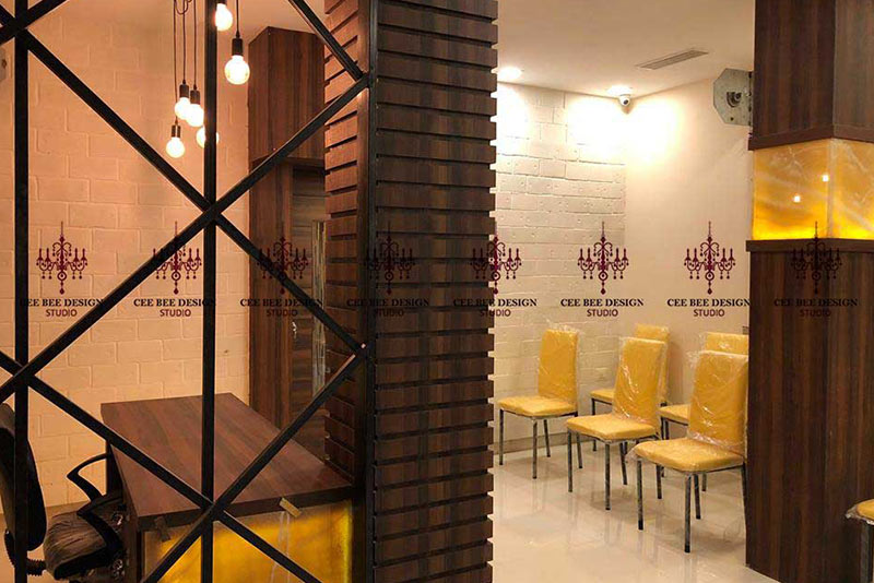 Wooden wall room with yellow chairs by interior designer in Kolkata