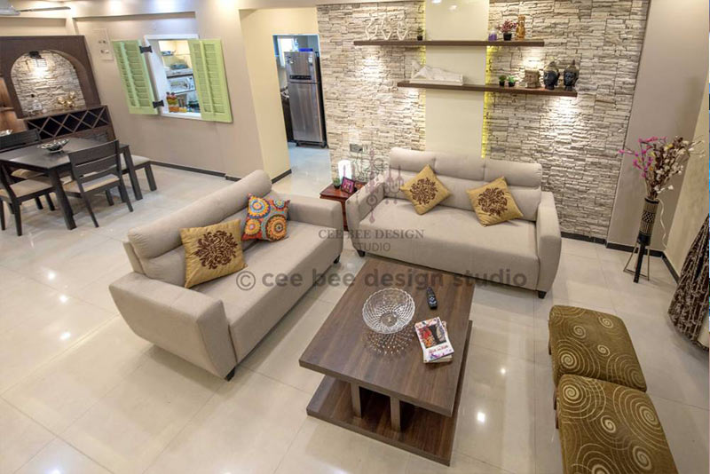 Living room in 3bhk apartment with couch, coffee table, and table.