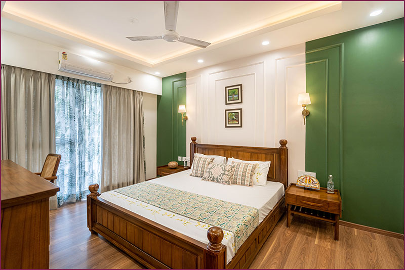 Bedroom with green walls and wooden floors in home interior design.