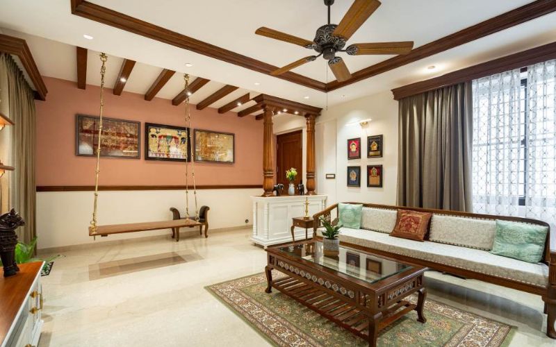 A beautifully decorated living room with a swing and a ceiling fan, reflecting a classic and timeless interior design style.