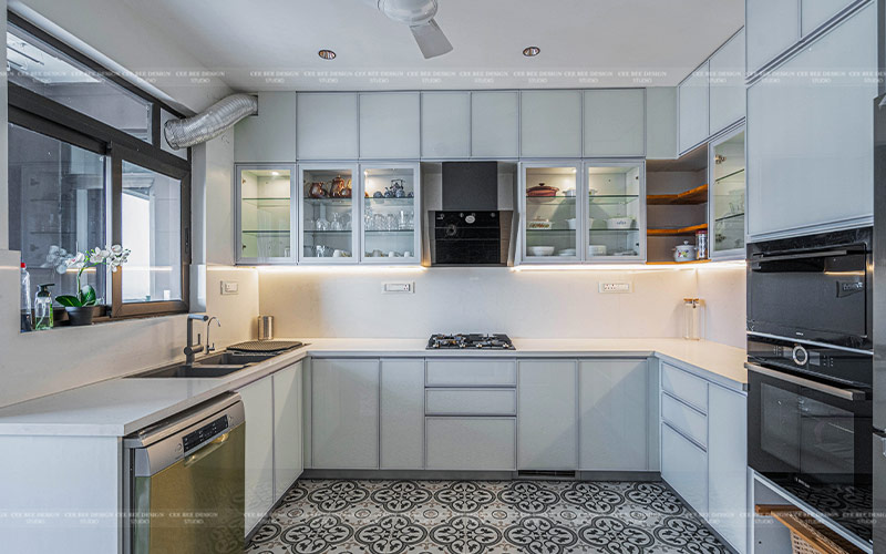 A beautifully designed kitchen showcasing white cabinets and a classic black and white tile floor.