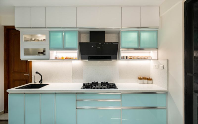 Stylish kitchen with a white countertop and blue cabinetry, created by an interior design company located in Bangalore.