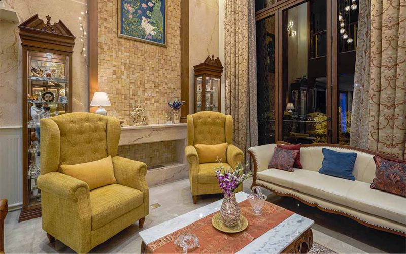 Elegant living room adorned with yellow chairs and a chic coffee table, showcasing luxury design from Bangalore's finest.