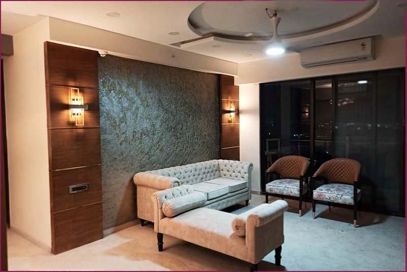 A luxurious living room featuring an elegant couch and stylish chairs, designed by top interior designers in Bangalore.