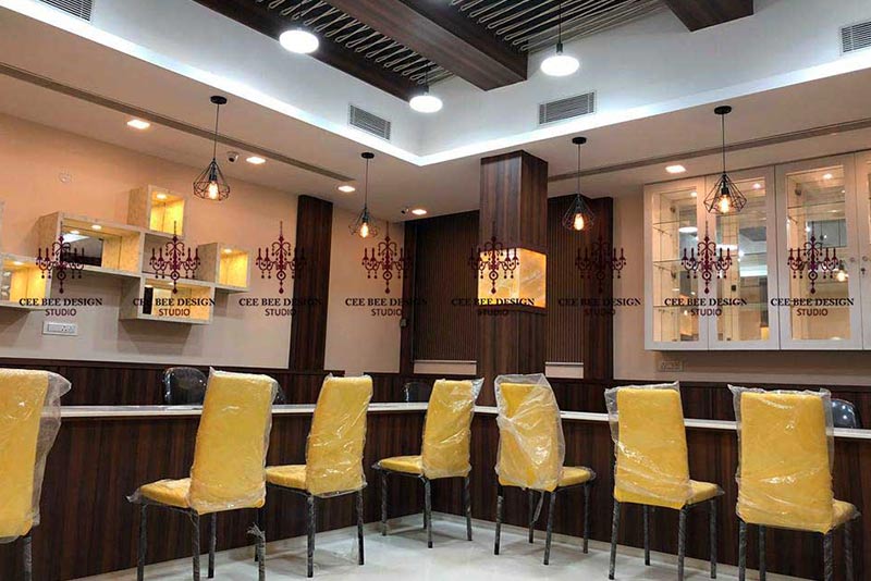 Interior of a jewellery showroom with yellow chairs and a counter.