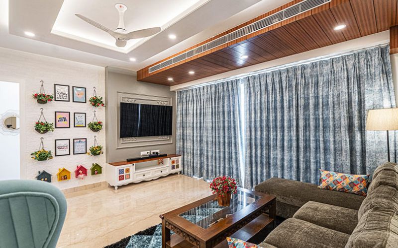 A stylish living room featuring a couch, television, and coffee table, designed by an interior designer in Kolkata.