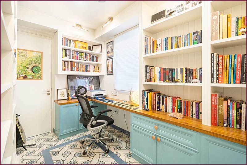 Home office featuring blue cabinets and desk, highlighting stylish interior design.