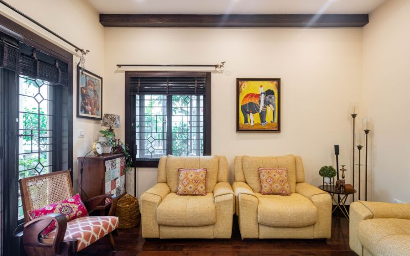 A stylish living room featuring two elegant couches and a captivating painting, designed by an interior designer in Bangalore.