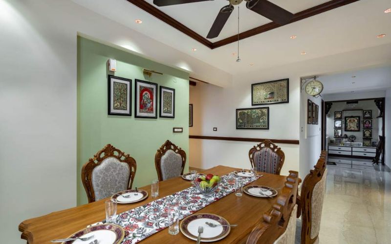 Dining room with ceiling fan and table, designed by interior designing company in Bangalore.