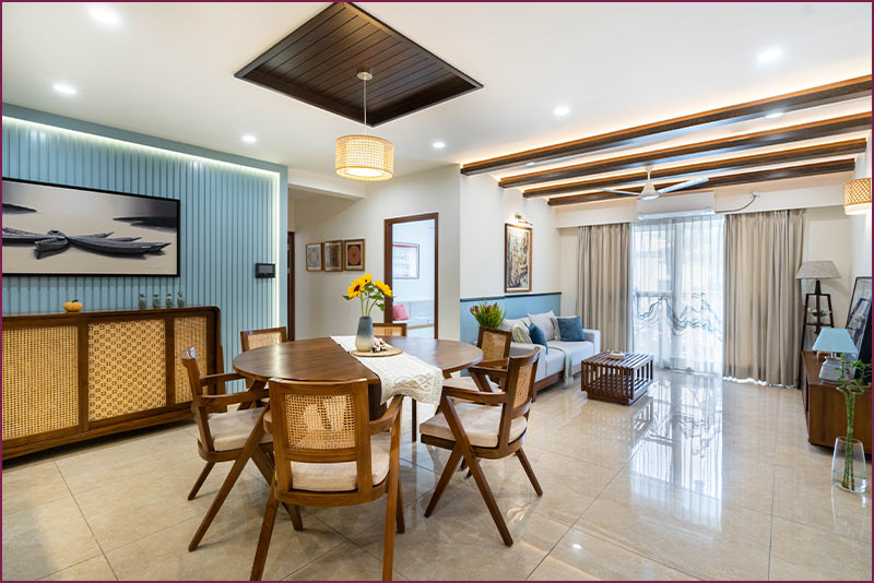 Blue-walled living and dining room with modern decor and natural lighting.