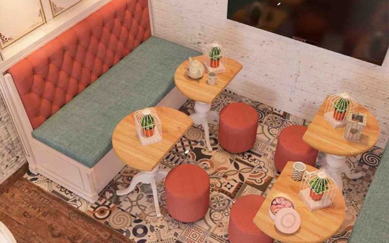 Cozy cafe in Bangalore with colorful stools and a television, offering a bright and engaging environment for customers.