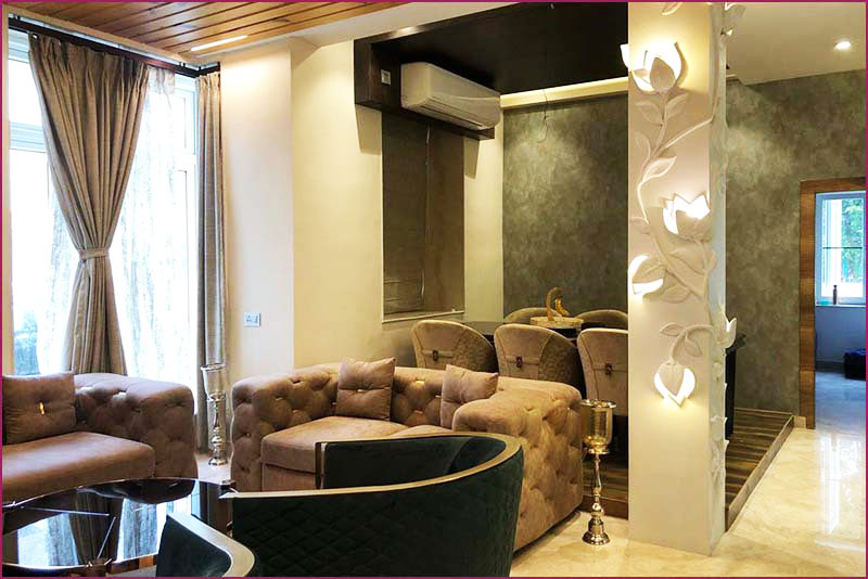 Luxurious living room with elegant couch, coffee table, and chairs by top interior designers in Bangalore.