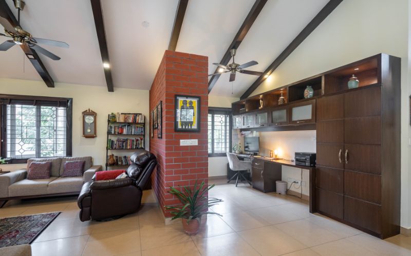 Karelian interior design with a dark wood cabinet, high ceiling with beams and a brightly lit, cozy living space.