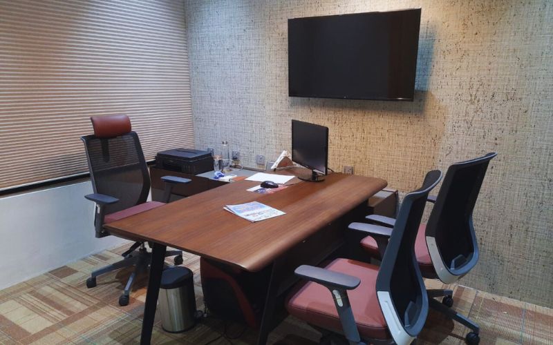 An elegant conference room with a contemporary desk and seating, highlighting the work of commercial interior designers in Bangalore.