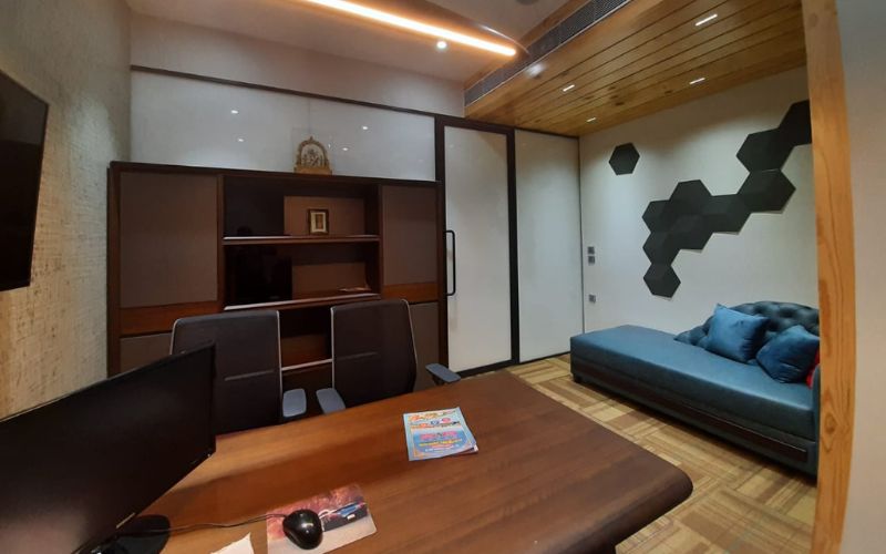 Sleek office interior with a cozy couch and a television, designed by professional interior designers in Kolkata.