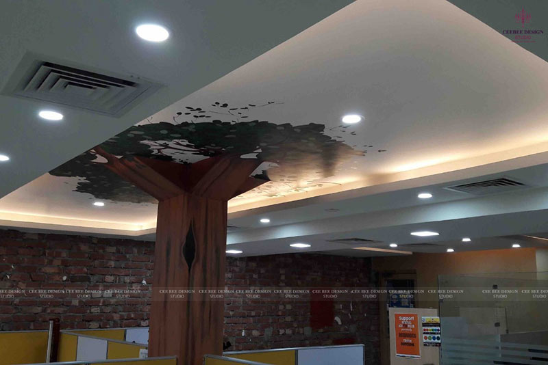 A spacious office in Kolkata with a tree mural on the ceiling design