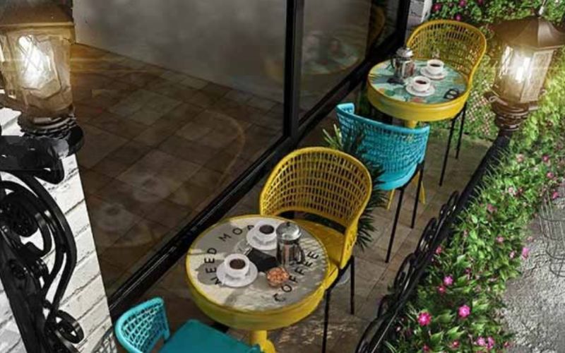 A charming balcony featuring chairs and tables, perfect for enjoying coffee in a Bangalore café setting.