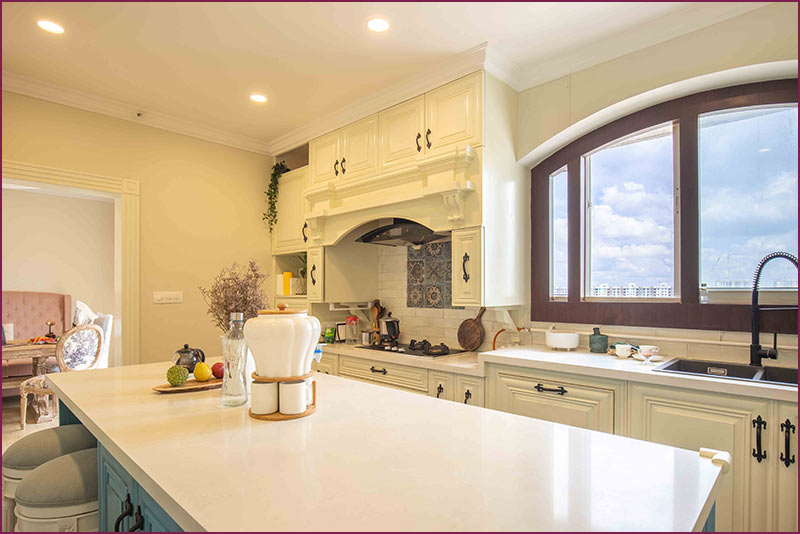 Elegant kitchen showcasing a large island and a bright window, crafted by a Bangalore-based interior design firm.