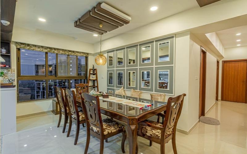 A beautifully designed dining room with a large window and a refined table, exemplifying the talent of Bangalore's leading interior designers.