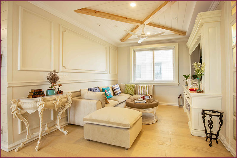 A stylish living room featuring a couch, coffee table, and ceiling fan, showcasing modern interior design in Bangalore.